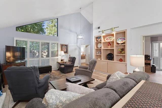 a living room with furniture a flat screen tv and a large window