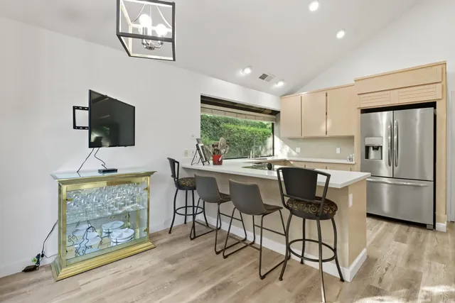 a kitchen with stainless steel appliances granite countertop a refrigerator and a stove top oven