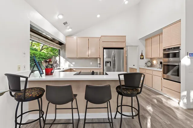 a kitchen with a dining table chairs and refrigerator