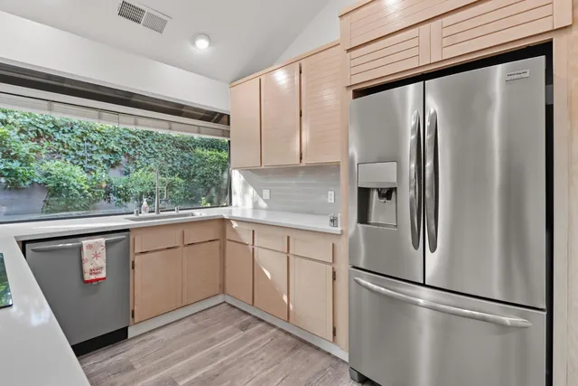 a kitchen with stainless steel appliances granite countertop a refrigerator and a sink
