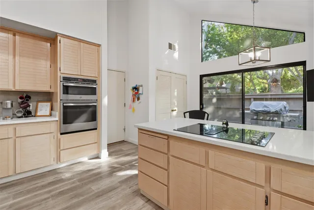 a kitchen with white cabinets and a window
