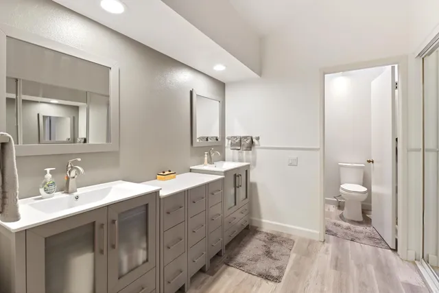 a spacious bathroom with a double vanity sink mirror and toilet