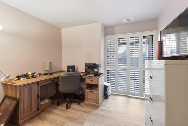 a view of a workspace with furniture and a window