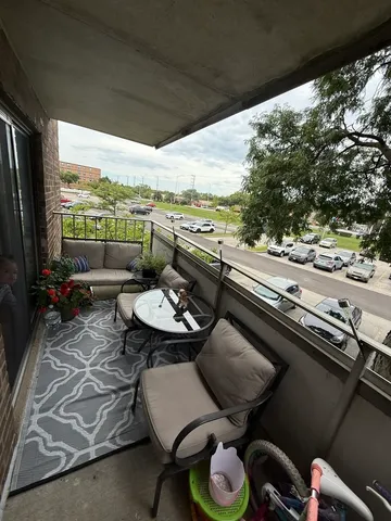a view of a balcony with furniture and floor to ceiling window