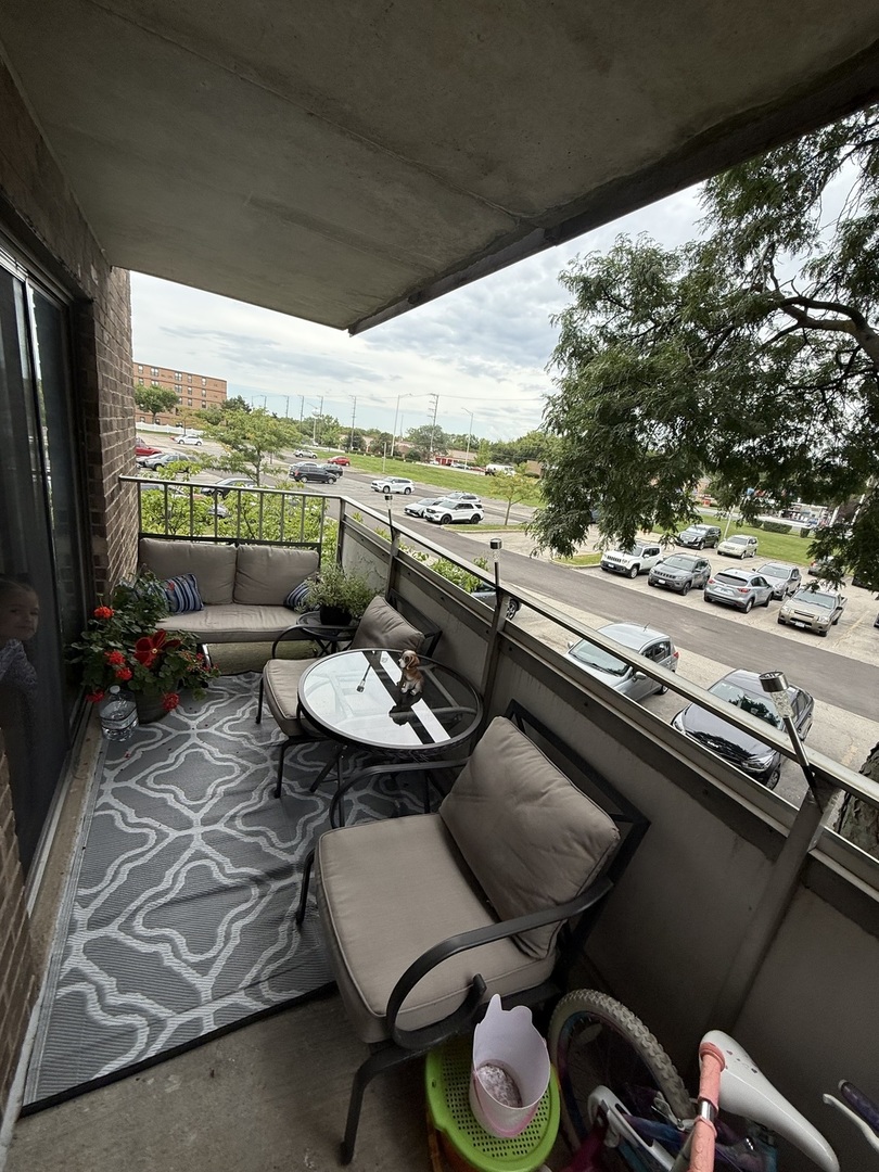 1460 Fairlane Drive, Unit 228 Schaumburg, IL 60193 - Photo 11 of 22 a view of a balcony with furniture and floor to ceiling window