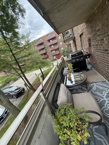 a view of a balcony with chairs and a stove