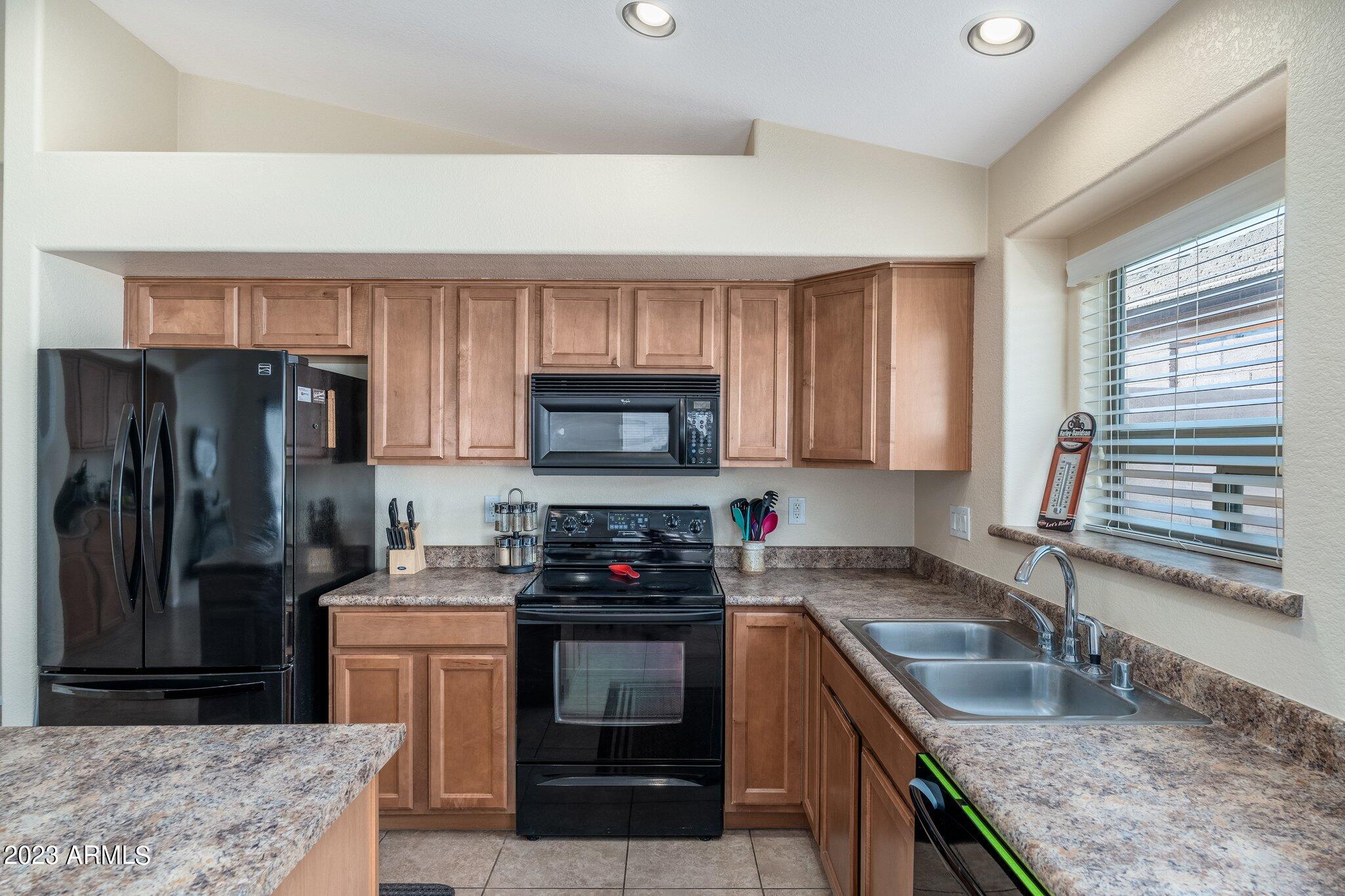 2215 West Peak View Road Phoenix, AZ 85085 - Photo 11 of 49 a kitchen with granite countertop a sink stove and refrigerator