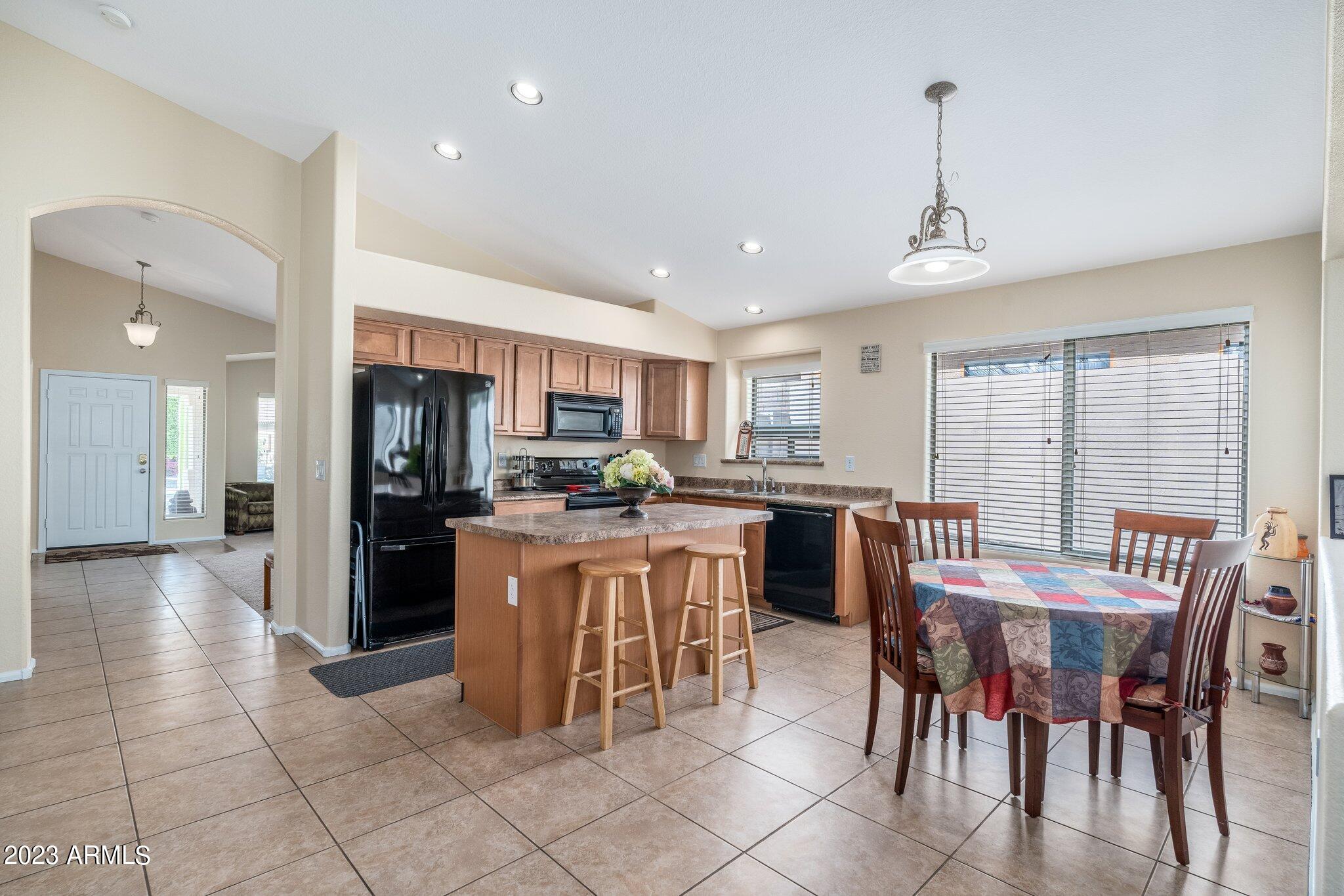 2215 West Peak View Road Phoenix, AZ 85085 - Photo 13 of 49 a kitchen with stainless steel appliances kitchen island granite countertop a refrigerator and cabinets