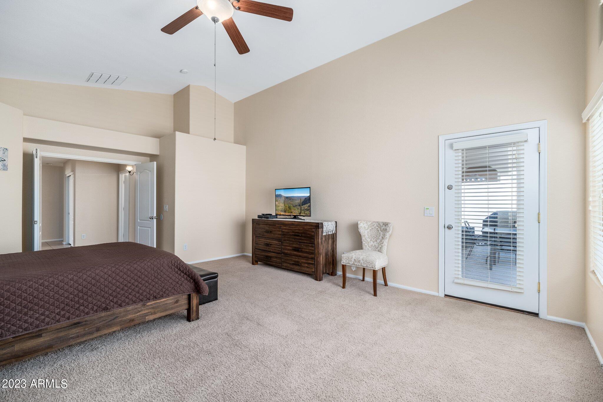 2215 West Peak View Road Phoenix, AZ 85085 - Photo 21 of 49 a spacious bedroom with a bed and a chandelier