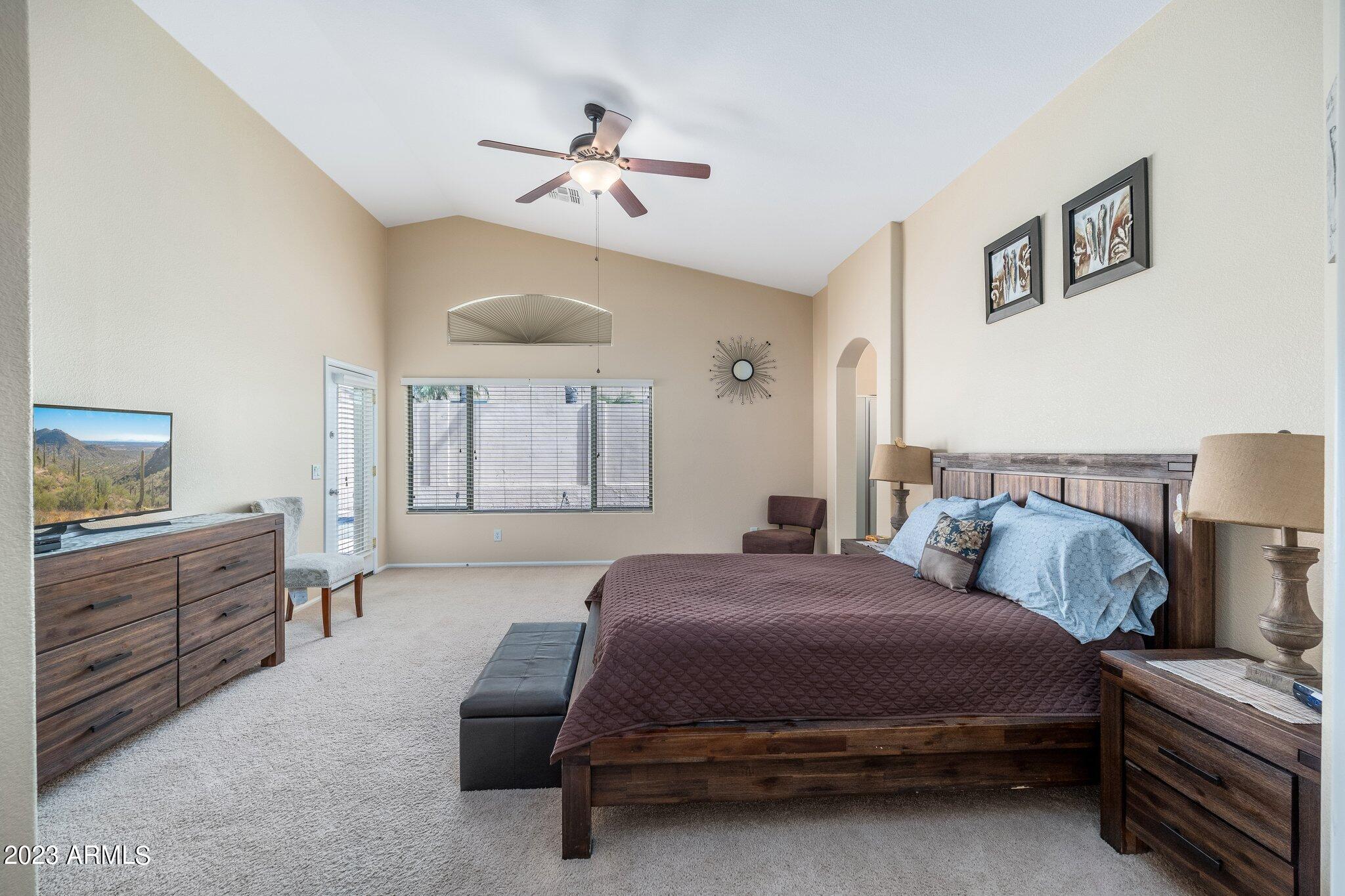 2215 West Peak View Road Phoenix, AZ 85085 - Photo 23 of 49 a spacious bedroom with a bed and a chandelier