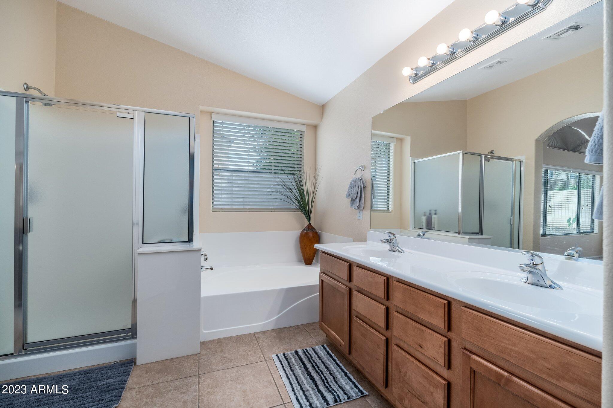 2215 West Peak View Road Phoenix, AZ 85085 - Photo 24 of 49 a bathroom with a tub a double vanity sink and mirror