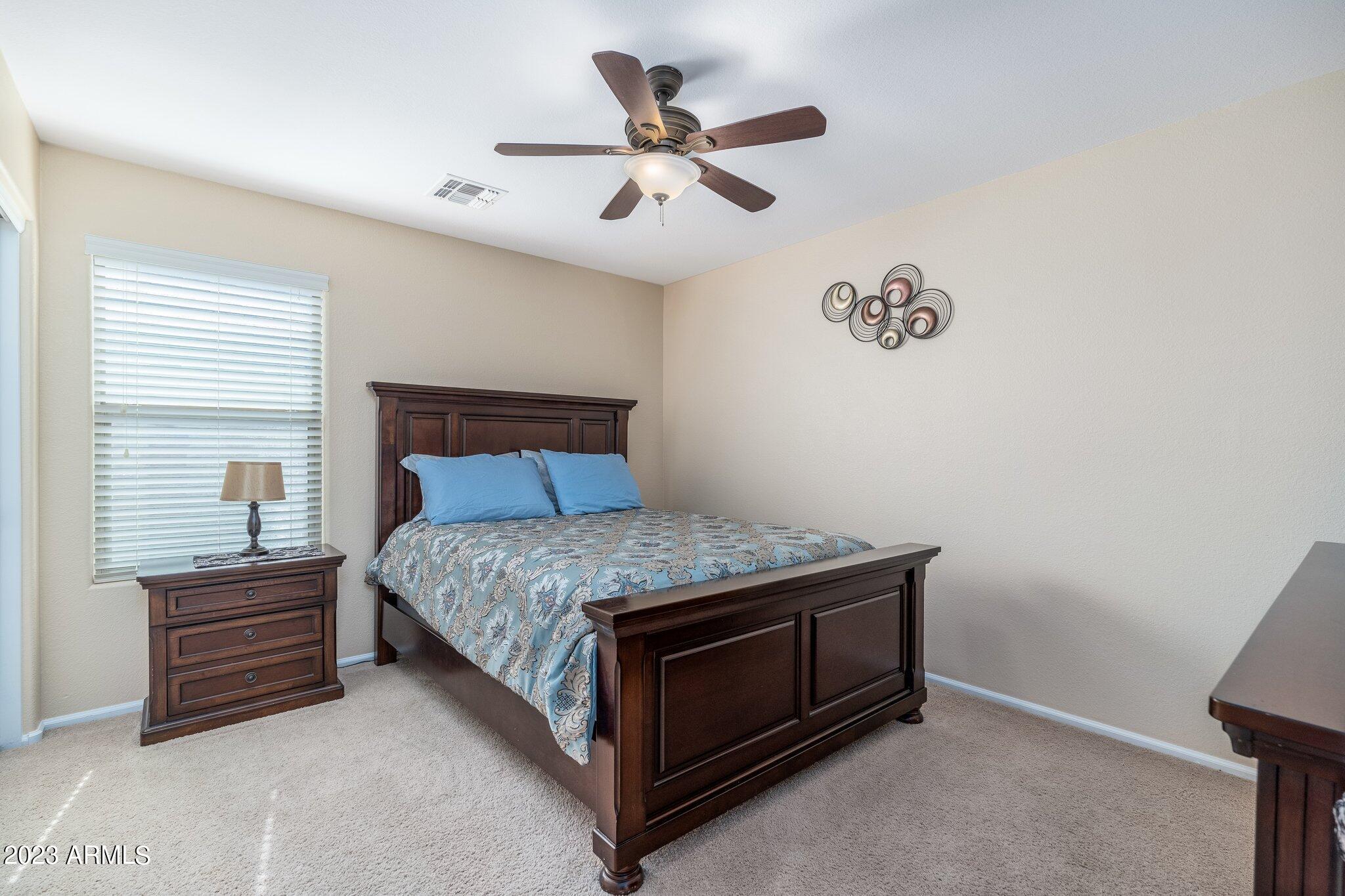 2215 West Peak View Road Phoenix, AZ 85085 - Photo 26 of 49 a bed sitting in a room next to a window and a chandelier
