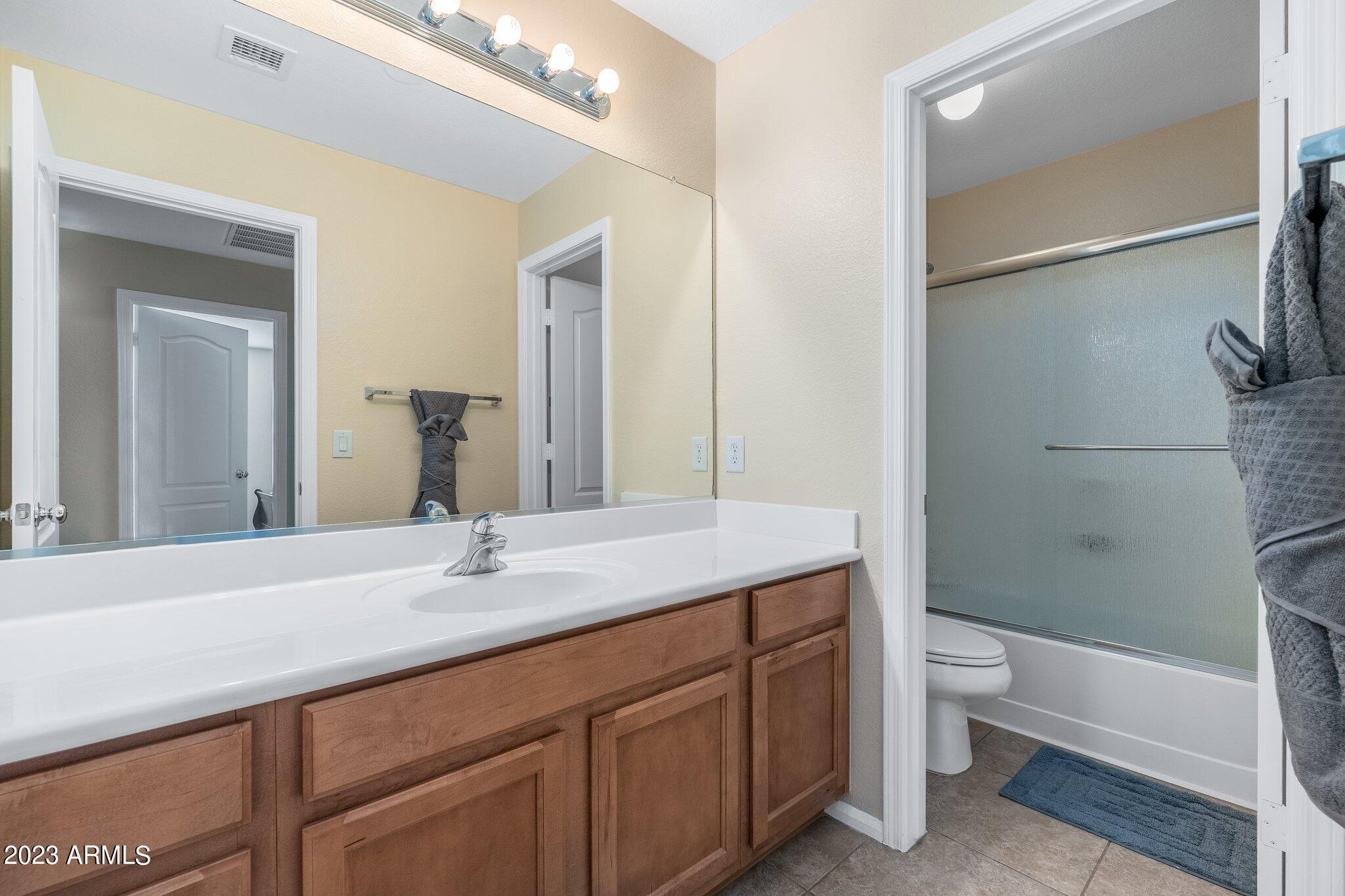2215 West Peak View Road Phoenix, AZ 85085 - Photo 30 of 49 a bathroom with a granite countertop sink a toilet and shower