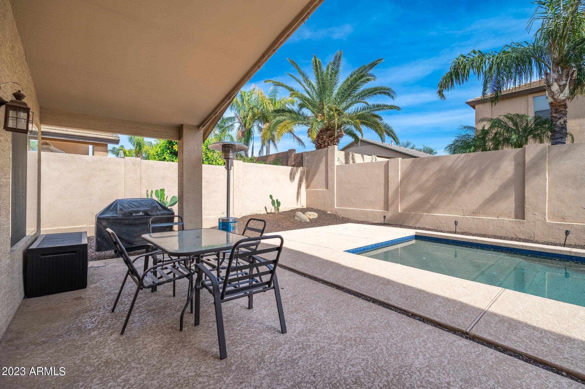 2215 West Peak View Road Phoenix, AZ 85085 - Photo 32 of 49 a patio with a table and chairs and potted plants