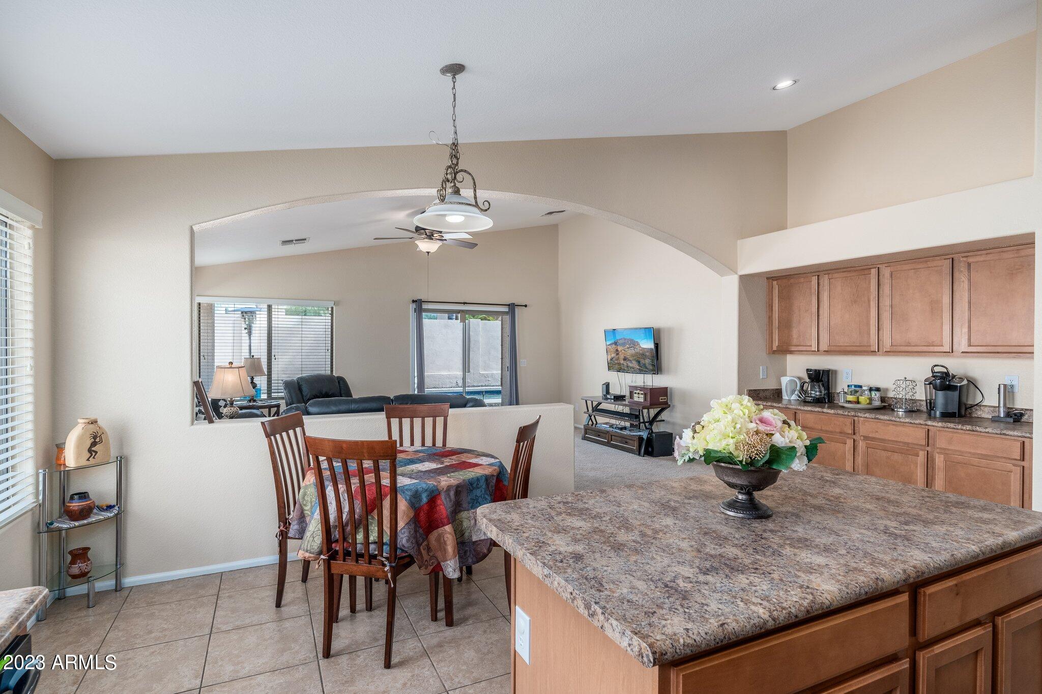 2215 West Peak View Road Phoenix, AZ 85085 - Photo 10 of 49 a view of a dining room and livingroom with furniture wooden floor a chandelier