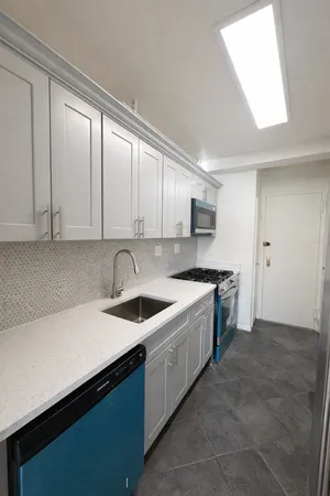 a kitchen with stainless steel appliances granite countertop a sink dishwasher a stove and a refrigerator with wooden cabinets