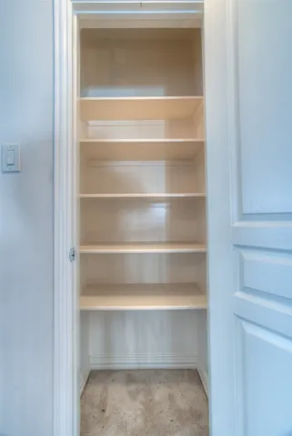 a view of walk in closet with empty racks