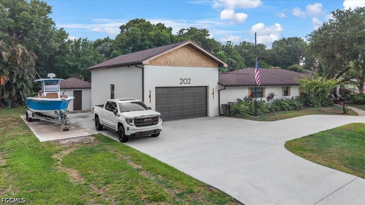 202 Ridgewood Avenue Clewiston, FL 33440 - Photo 4 of 50 a car parked in front of house with a yard