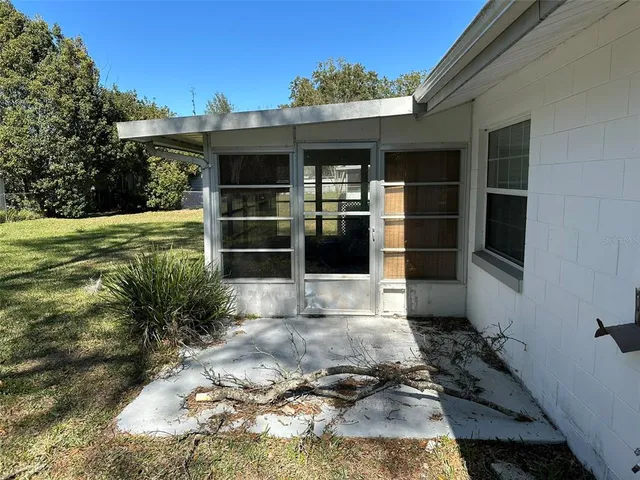 a view of backyard with large window and wooden fence
