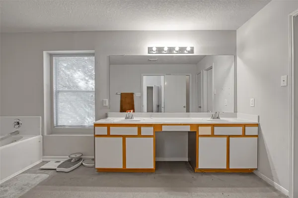 a view of a room with kitchen island stainless steel appliances wooden floor and view living room