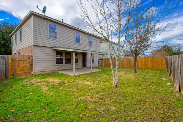 a view of a house with a big yard and large trees