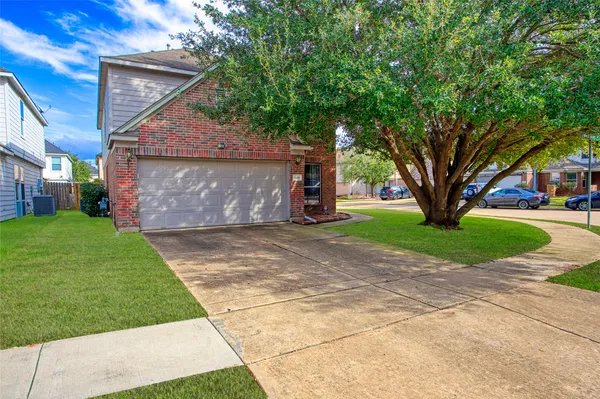 a front view of a house with a garden and tree
