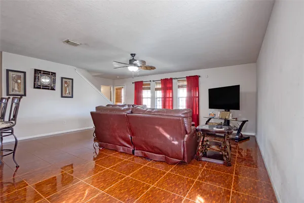a living room with furniture a flat screen tv and kitchen view