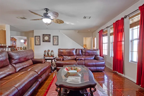 a living room with furniture a large window and a chandelier