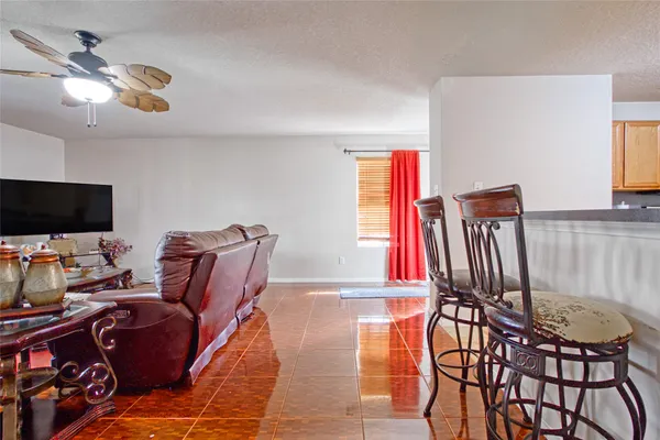 a living room with furniture a flat screen tv and a window