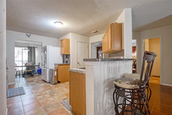 a kitchen with a table chairs refrigerator and microwave