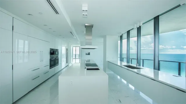 a large white kitchen with cabinets