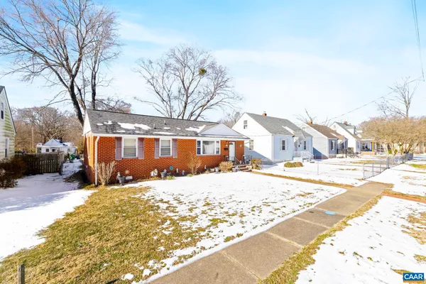 a view of a large white house with a yard covered in snow