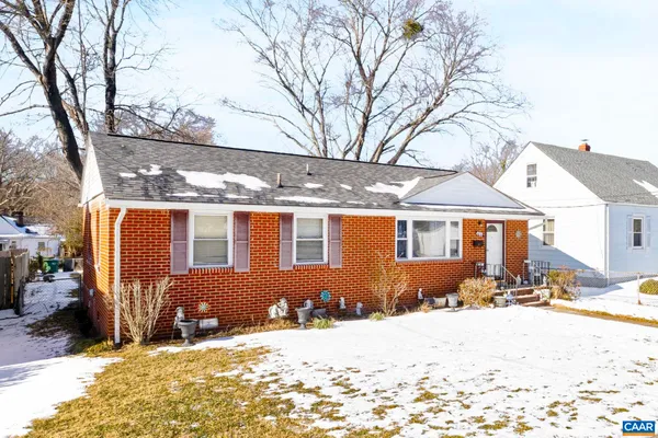 a front view of a house with a yard covered in snow