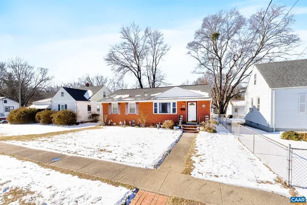 a front view of a house with a yard covered with snow