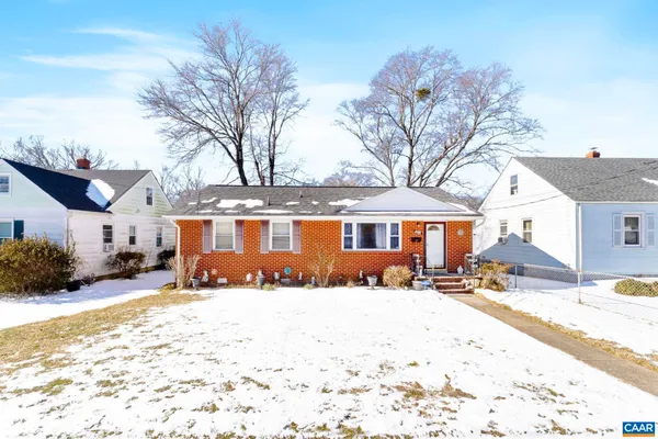 a front view of a house with a yard covered in snow