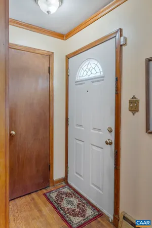 a view of a hallway with wooden floor and a bathroom