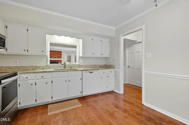 a kitchen with granite countertop white cabinets and white appliances