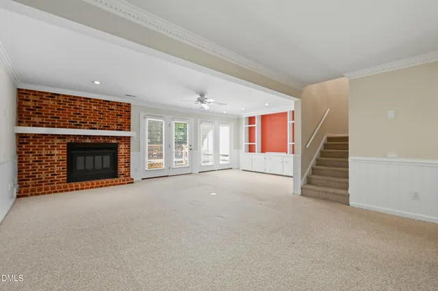 a view of empty room with fireplace and stairs
