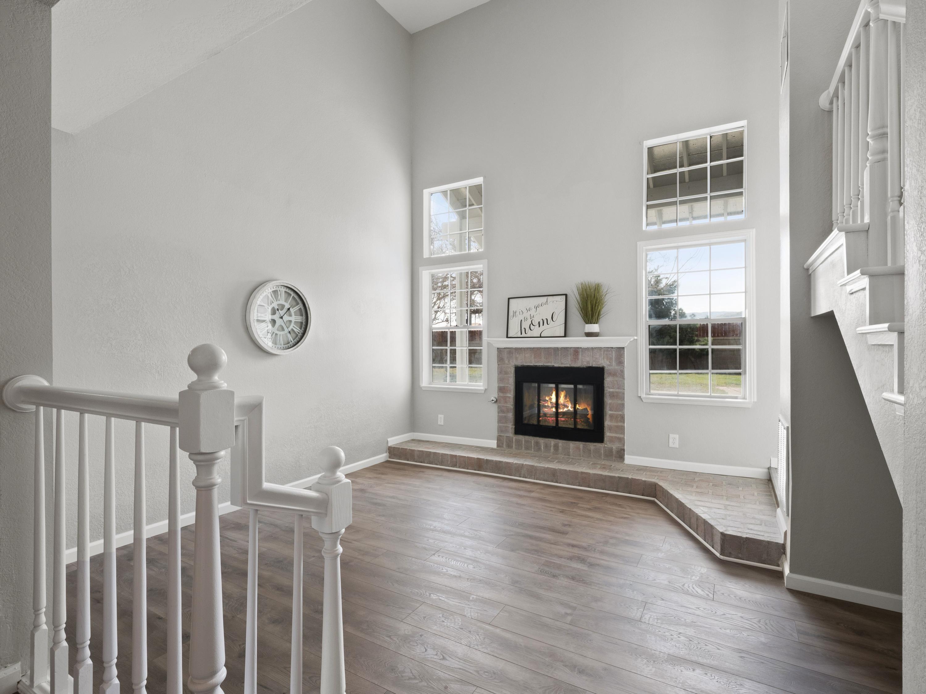 6002 Caleche Road Lancaster, CA 93536 - Photo 6 of 31 a view of a livingroom with a fireplace a ceiling fan and windows
