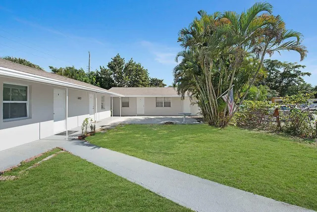 a backyard of a house with table and chairs