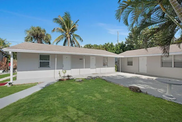 a front view of house with a garden and yard