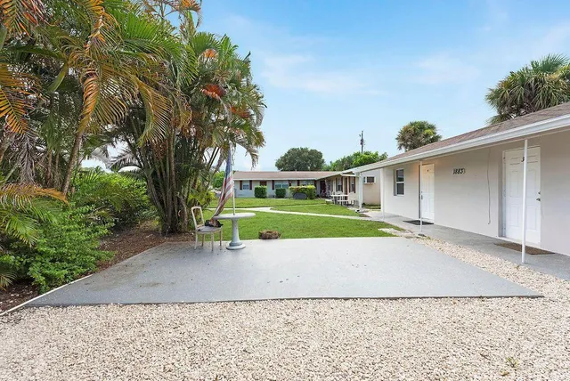 a view of a house with a backyard and a tree