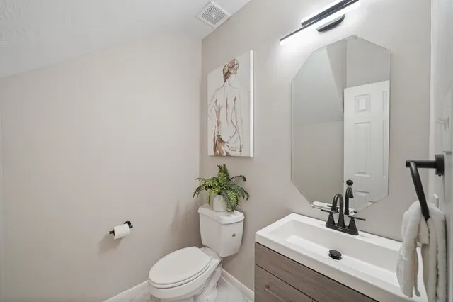 a bathroom with a sink mirror and toilet