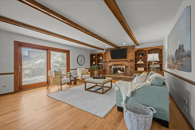 a living room with furniture a large window and wooden floor