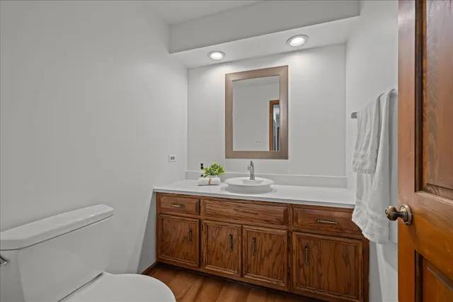 a bathroom with a toilet a sink a vanity and mirror