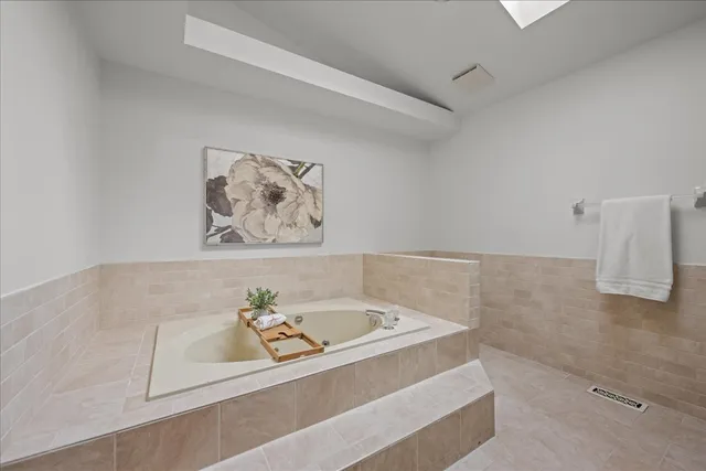 a white bath tub sitting next to a white cabinet