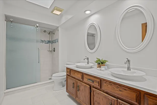 a bathroom with a granite countertop toilet a sink and a mirror