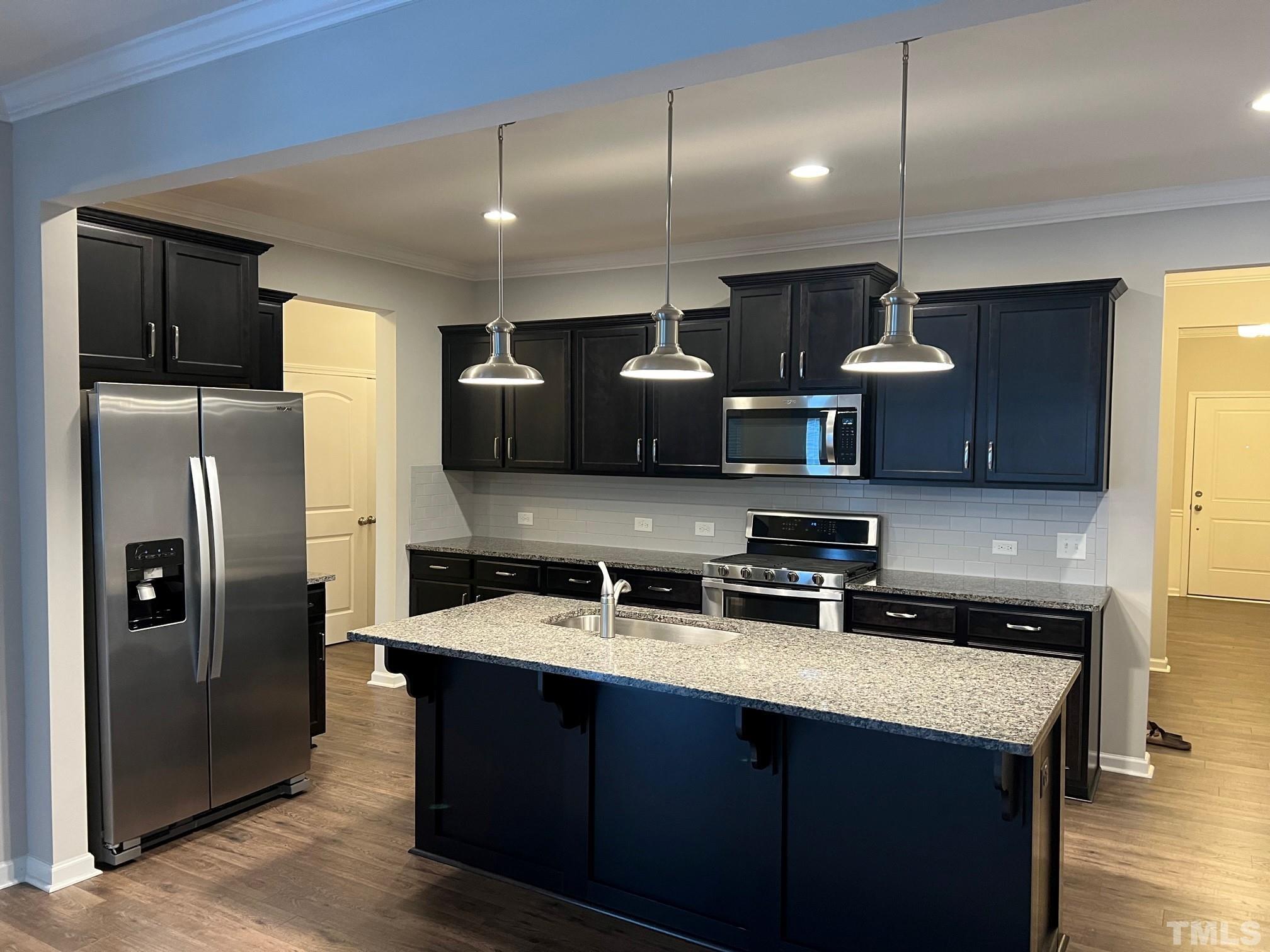 562 Metro Station Apex, NC 27502 - Photo 4 of 19 a kitchen with stainless steel appliances granite countertop a sink a stove and a refrigerator
