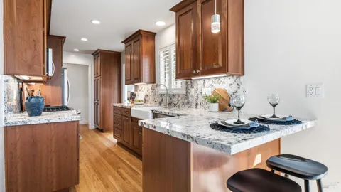 a kitchen with kitchen island granite countertop a sink and cabinets