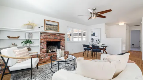 a living room with furniture a fireplace and a large window